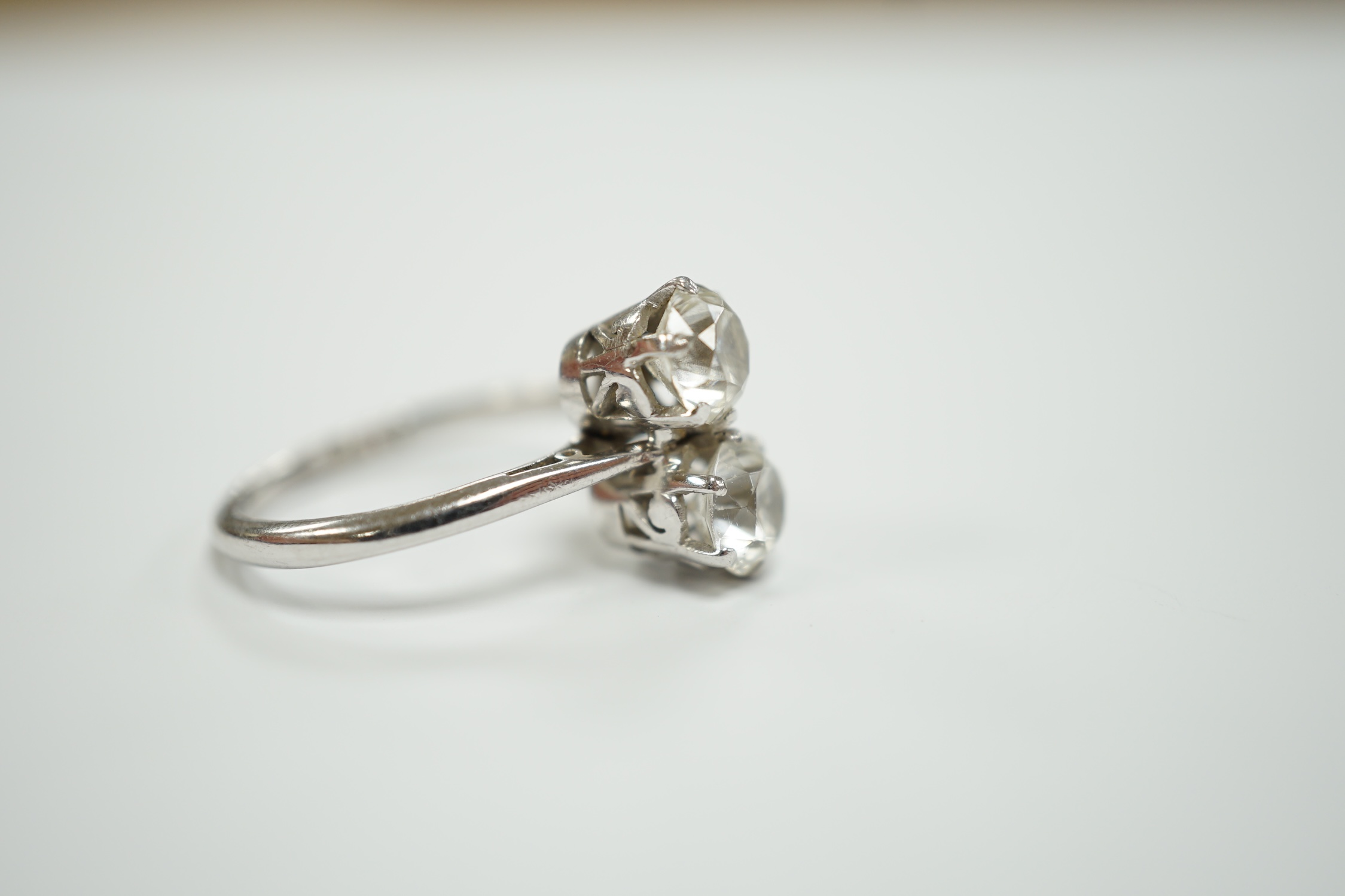 A mid 20th century white metal (stamped plat) and two stone white zircon? set ring, size M, gross weight 4.9 grams.